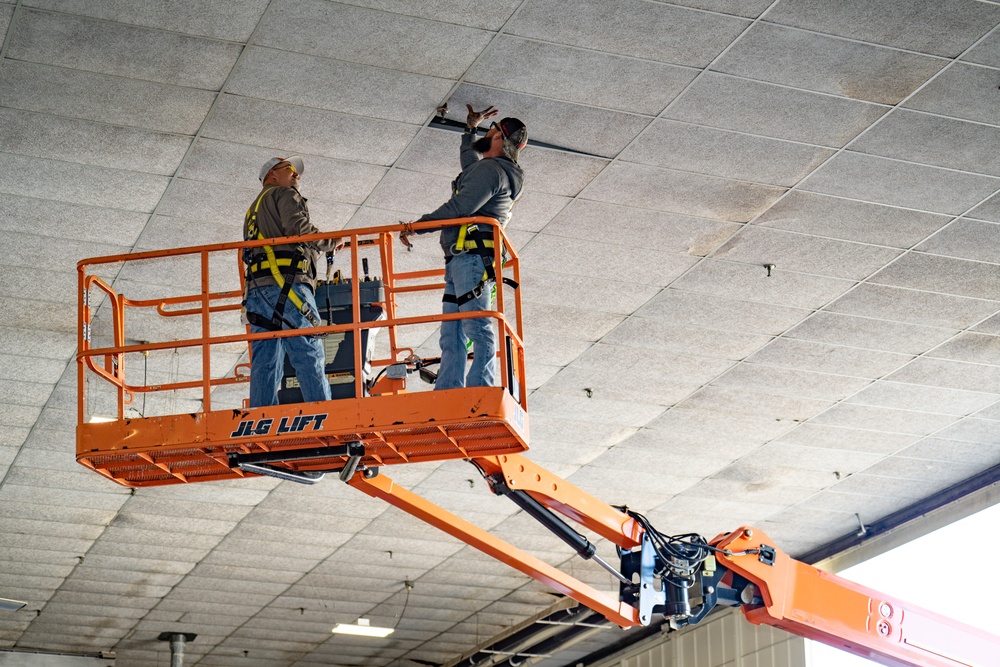 Maintenance crew inspecting an overhead fire suppression system